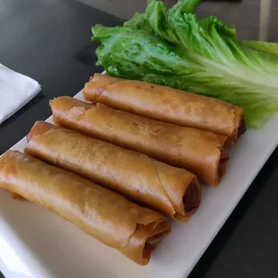 a plate of spring rolls and lettuce
