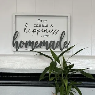 a potted plant in front of a sign that says, our happiness is homemade