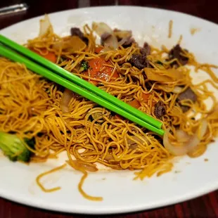 a plate of noodles with chopsticks