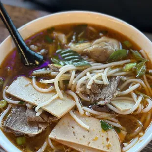 a bowl of soup with tofu and vegetables