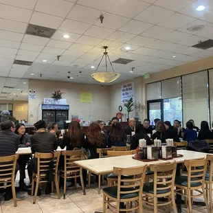 a group of people sitting at tables in a restaurant