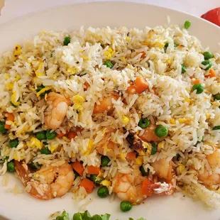 a plate of rice with shrimp and peas