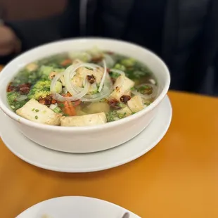 a bowl of soup and a plate of noodles