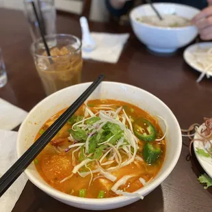 a bowl of soup with chopsticks