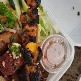 grilled chicken skewers on a bed of rice