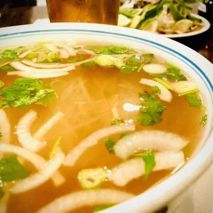 Pho and fresh toppings resting in the background