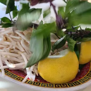 two lemons on a plate with noodles