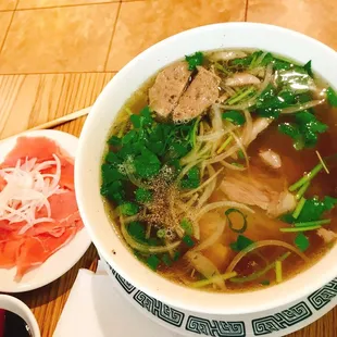 a bowl of pho vinh with meat and vegetables