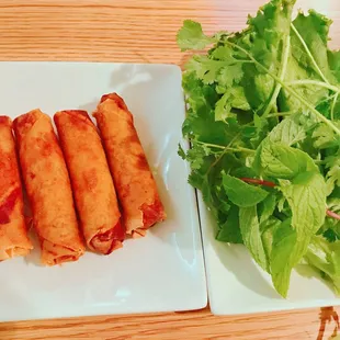 a plate of spring rolls and a salad