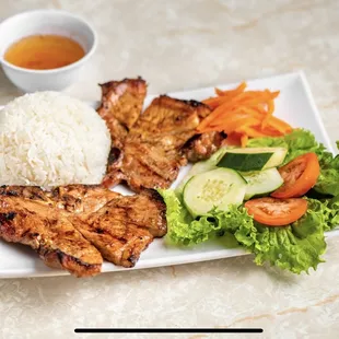 a plate of chicken, rice, and vegetables