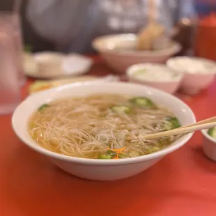 a bowl of noodles with chopsticks
