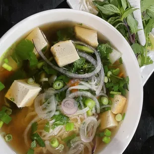 Vegan pho with tofu, carrots, broccoli and other veggies in a vegetable broth