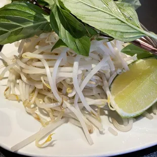 a plate of noodles and a lime