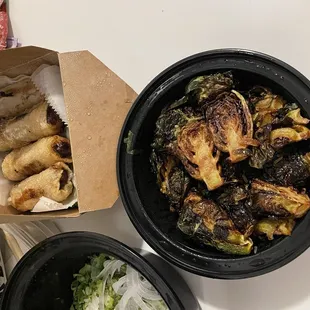 Close up of Crispy Brussels Sprouts and fried pork and shrimp spring rolls
