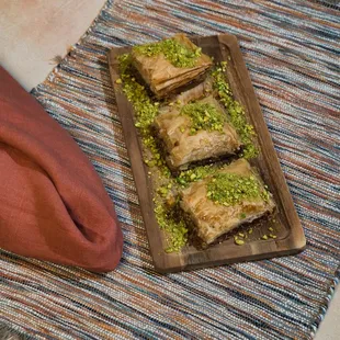 Baklava: Layers of delicate phyllo dough are filled with chopped walnuts and butter, then soaked in rosewater syrup. Made in-house, our bakl