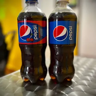 two bottles of pepsi on a table