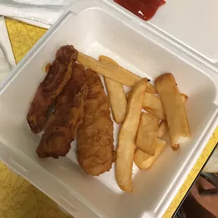 a takeout container with french fries and ketchup