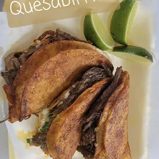 a plate with a sandwich and lime wedges