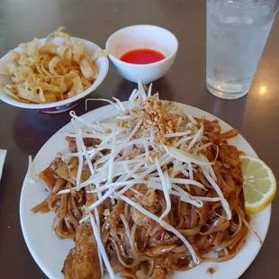 a plate of noodles and a glass of water