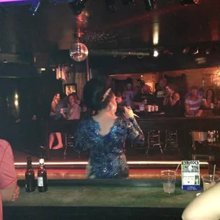 a woman in a blue dress at a bar