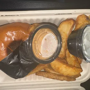 a sandwich and fries in a styrofoam container