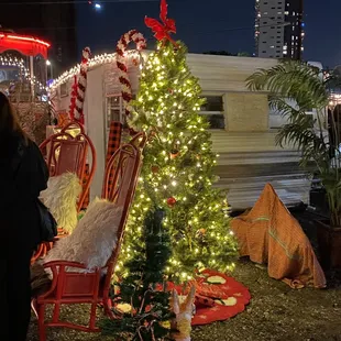 a decorated christmas tree in front of a trailer