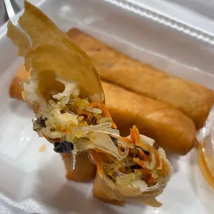 a hot dog with a fork in a styrofoam container