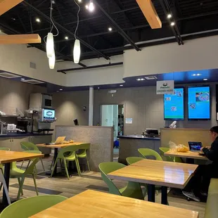 a restaurant with tables and green chairs