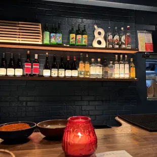 bottles of alcohol on shelves above a bar