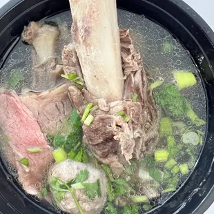 a pot of soup with meat and vegetables