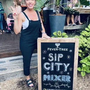 a woman standing in front of a stop city mixer sign