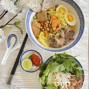 a bowl of noodles, meat and vegetables