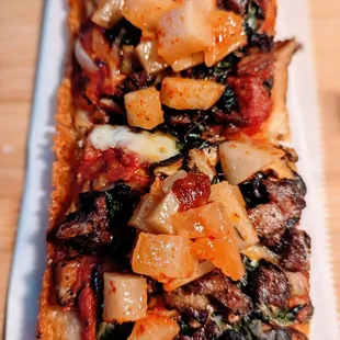 a flatbread pizza with onions, peppers, and spinach