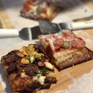 two pieces of pizza on a cutting board