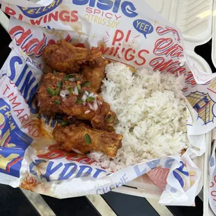 chicken wings and rice in a styrofoam container