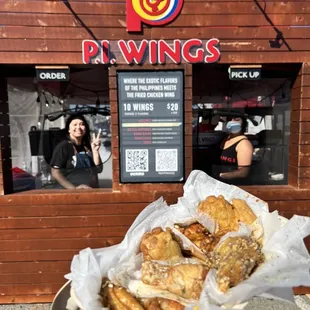a person holding a basket of chicken wings