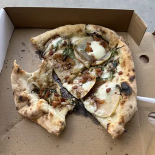 a half eaten pizza in a box