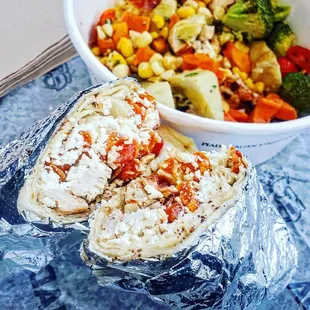 a burrito and a bowl of vegetables
