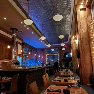 Old school tin ceiling tiles and lights, beautiful live edge tables and wood accents, cozy and intimate space