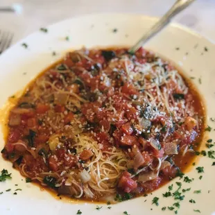a plate of spaghetti with sauce and parmesan cheese