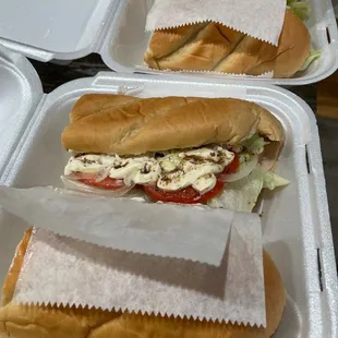 two sandwiches in a styrofoam container