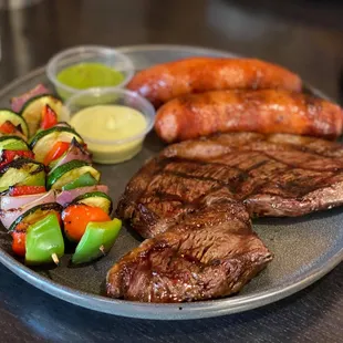 Picanha Steak Plate with extra sausage and grilled vegetables. Cooked medium-rare.