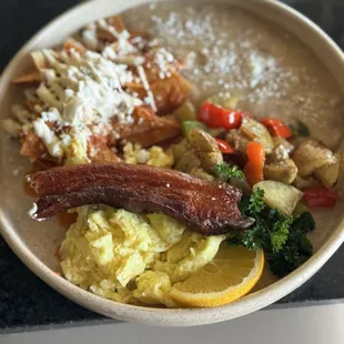 Unreal pork belly on eggs with their refried beans and chips with a red sauce and cheese!