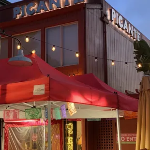 the outside of a restaurant with tables and umbrellas