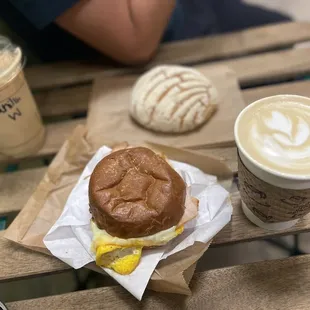 Iced vanilla latte, cafe de olla latte, concha and breakfast sandwich