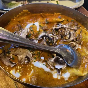 Agnolotti fatti in casa ripieni con porcini con rag di agnello, e vellutata di parmigiano