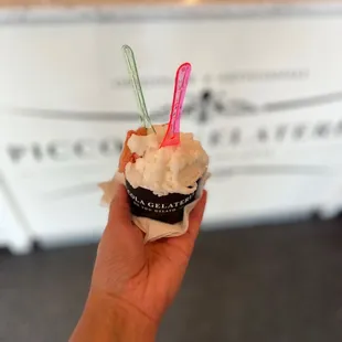 a hand holding a cupcake