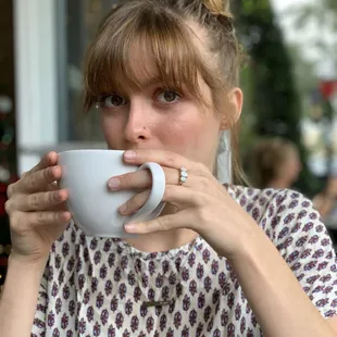 a woman drinking a cup of coffee