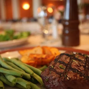 a steak and green beans on a plate