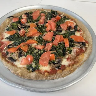 a pizza with tomatoes and spinach